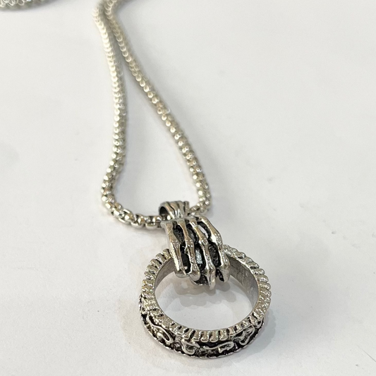 Gripping skeleton hand necklace.